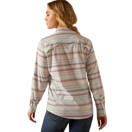 Woman wearing a striped long-sleeve shirt and jeans on a beige background